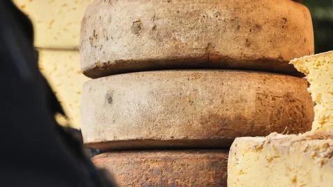 Rustic artisan cheese wheels stacking, showcasing dairy product aging process Stock Photos