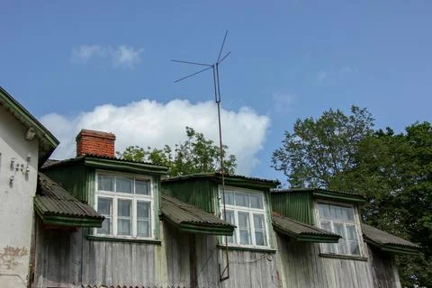 Rustic Attic Windows with TV Antenna Against Blue Sky Fotos de archivo