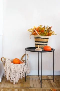 Rustic autumn decorations featuring pumpkins and woven basket in cozy home .. Stock Photos
