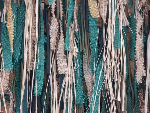 Rustic background with hanging strips of teal fabric, burlap, and natural r.. Stock Photos