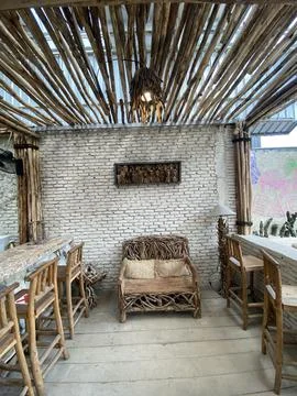 Rustic bamboo-themed cafe interior with natural wood furniture Stock Photos