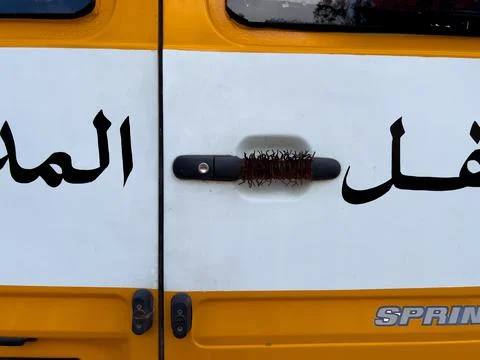 Rustic barbed wire covering the door handle of a school bus in Morocco Stock Photos