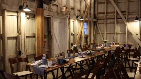 Rustic barn event space with long dining tables Stock Footage 338035143