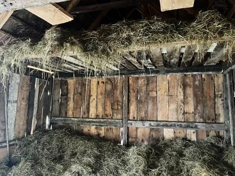 Rustic barn interior with hay storage on wooden beams and loft Stock Photos
