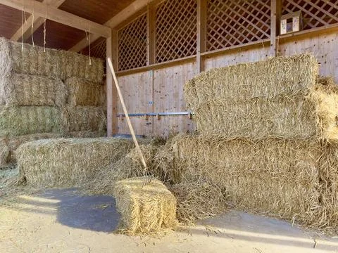 A rustic barn interior with stacks of hay Stock Photos
