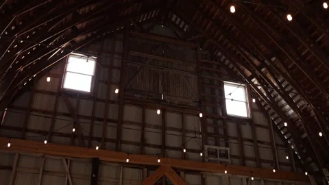 Rustic barn interior with string lights and wooden roof Stock Footage 338034838