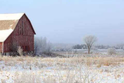 Rustic barn next to a field on a cold day Stock Photos