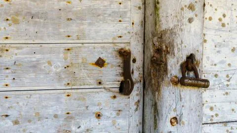 Rustic barn white door and padlock. Wooden planks and locks closeup. Peeling  Stock Photos