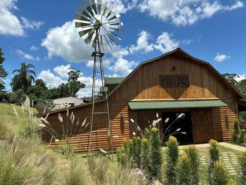 Rustic Barn with Windmill and Plants Stock Photos