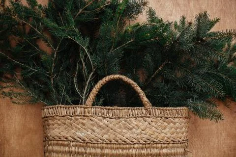 Rustic basket with fir branches on rustic wooden background. Flat lay. Winter Stock Photos