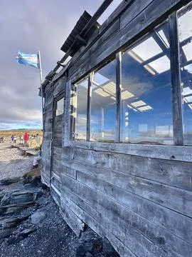 Rustic beach cabin under cloudy sky Stock Photos