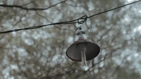 Rustic Bell Hanging on Wire with Blurred Trees in Background Captured with .. Stock Footage 303340760