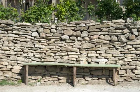 Rustic bench in front of a stone wall 库存照片