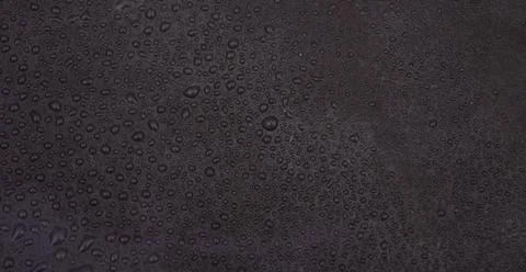 Rustic black background with fresh water droplets closeup view Stock Photos