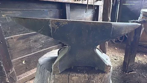 Rustic blacksmith anvil on tree stump Stock Photos