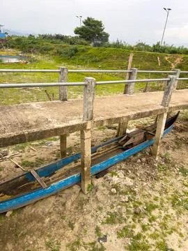 Rustic Blue Boat Under a Concrete Bridge by a Dry Shore Stock Photos