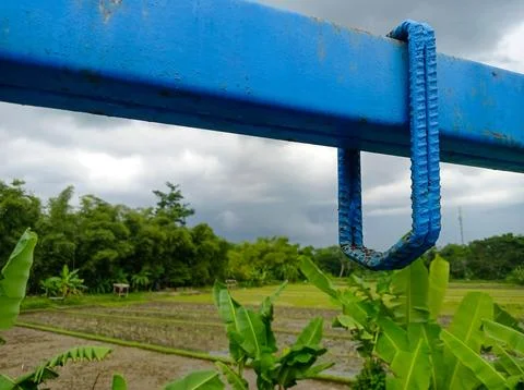 Rustic Blue Metal Structure and Rebar Against a Scenic Rural Backdrop of Ri.. 스톡 사진