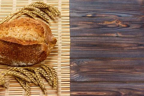 Rustic bread and wheat on an old vintage planked wood table. background wit.. Stock Photos