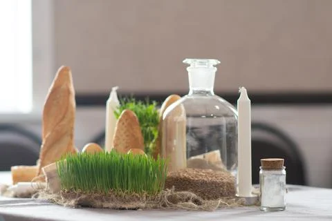 Rustic bread and wheatgrass on a table setting with candles Stock Photos