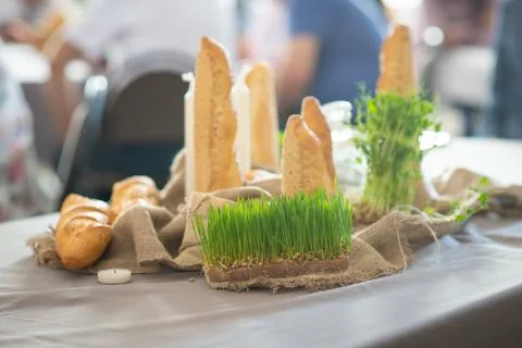 Rustic bread and wheatgrass on a table setting with candles Stock Photos