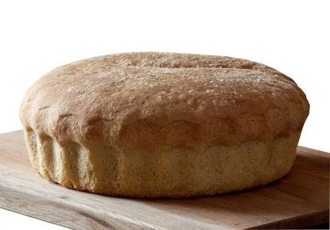 Rustic bread baked by hand from wheat flour. Isolated on a wooden board Stock Photos