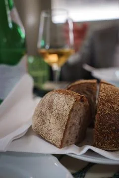 Rustic bread in basket, wine on table at luxury hotel in Rome. Stock Photos