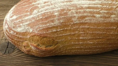 Rustic bread on an old vintage planked wood table Stock Footage 78749810