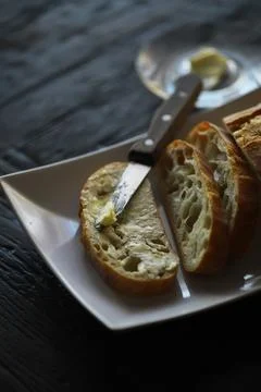 Rustic Bread Slices with Butter and Knife on White Plate Stock Photos