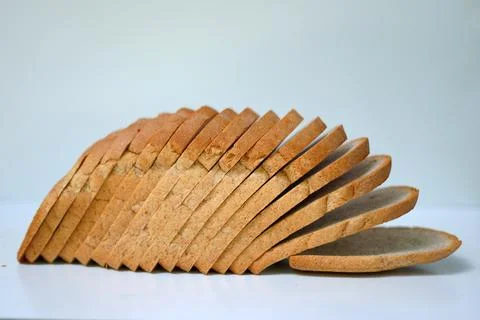 Rustic bread slices on plain white background. Stock Photos