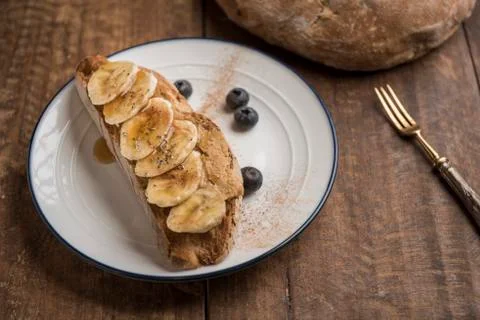 Rustic bread toast with peanut butter, banana and blueberries Stock Photos