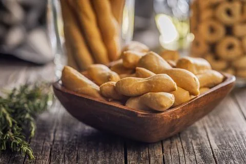 Rustic Breadsticks And Bite-Sized Savory Snacks In Wooden Bowl On Weathered.. Stock Photos