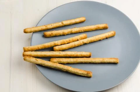 Rustic breadsticks in a dish on wood table, close up, background Stock Photos