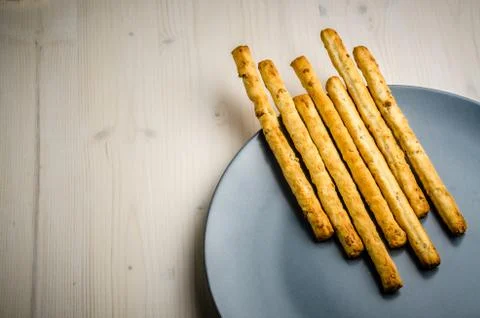 Rustic breadsticks in a dish on wood table, close up, background.. Stock Photos