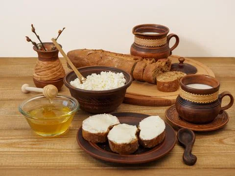 Rustic breakfast in earthenware on a wooden table. Natural rural dairy products Stock Photos