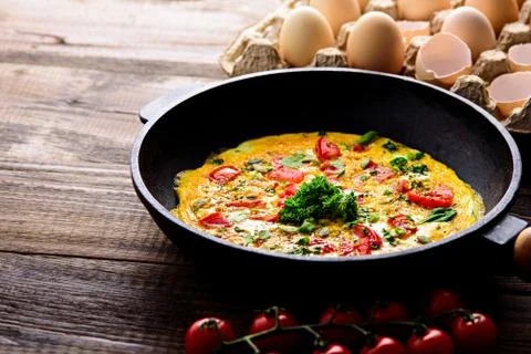 Rustic Breakfast, scrambled eggs with greens, tomatoes and pumpkin seeds on b Foto stock