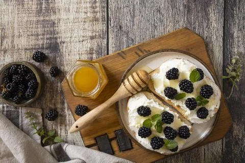 A rustic breakfast spread showcasing two bagels topped with cream cheese, fre Stock Photos