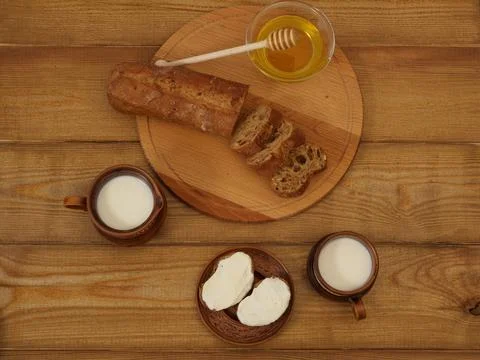 Rustic breakfast on a wooden table in earthenware. Natural milk, toast with curd Stock Photos