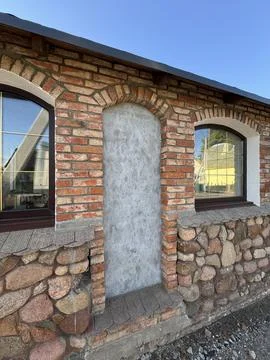 Rustic Brick and Stone Wall with Arched Windows Stock Photos