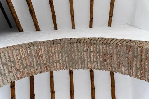 Rustic Brick Arch and White Plastered Ceiling with Wooden Beams 写真素材