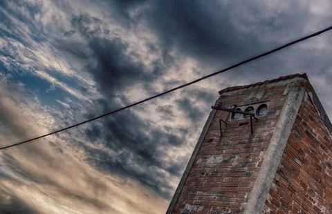 Rustic Brick Chimney Under a Dramatic Cloudy Sky in HDR Photo Technique Stock Photos