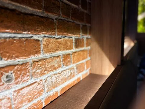 Rustic Brick Wall with Backlighting and Dark Wood Trim Foto stock