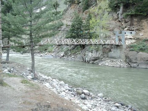 Rustic Bridge Over a Flowing Mountain River Stock Photos