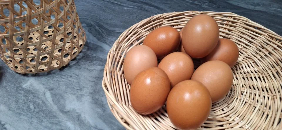 Rustic Brown Eggs in a bamboo basket. Stock Photos