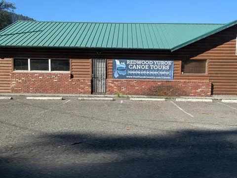 Rustic brown log building with a sign “Redwood Yurok Canoe Tours” Stock Photos