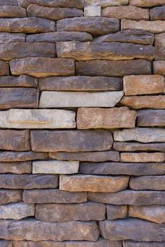 Rustic Brown Stacked Stone Wall Texture with Natural Architectural Finish Stock Photos
