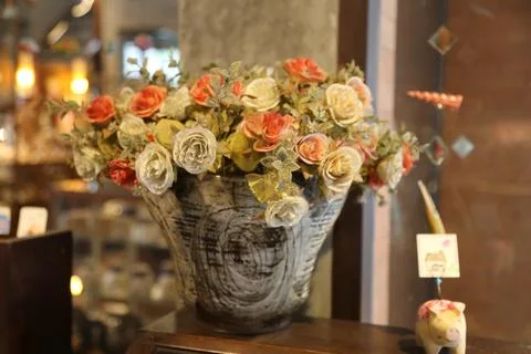A rustic bucket filled with an array of roses and lace details, sitting on .. Stock Photos