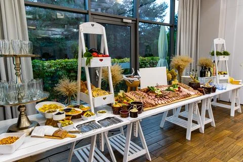 Rustic buffet table with cold cuts, cheese, and appetizers. Elegant buffet setup Stock Photos