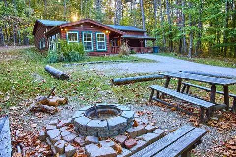 Rustic Cabin and Fire Pit in Autumn Forest Eye Level Perspective 스톡 사진