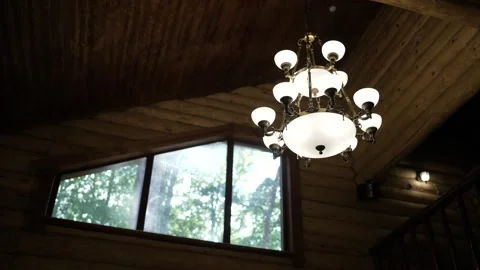 Rustic cabin ceiling chandelier illuminating wooden interior space Stock Footage 302923361