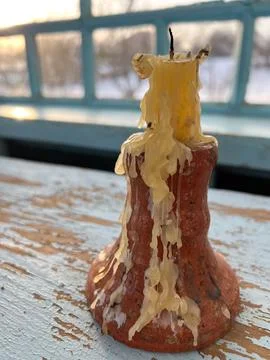 A Rustic Candle with Dripped Wax Placed Elegantly by a Sunlit Window Creating Stock Photos